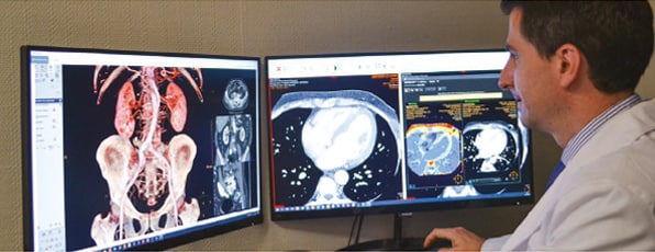 Professional checking CT and MR scans at monitor