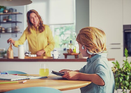 Poiss vaatab videoid, kasutades Philipsi kõrvu mittekatvaid juhtmevabasid laste kõrvaklappe