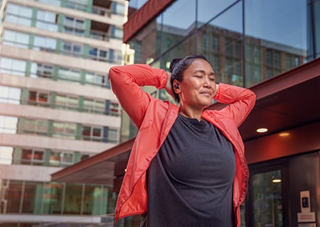 Naine, kes kasutab õues juhtmeta kõrvaklappe Philips A5508