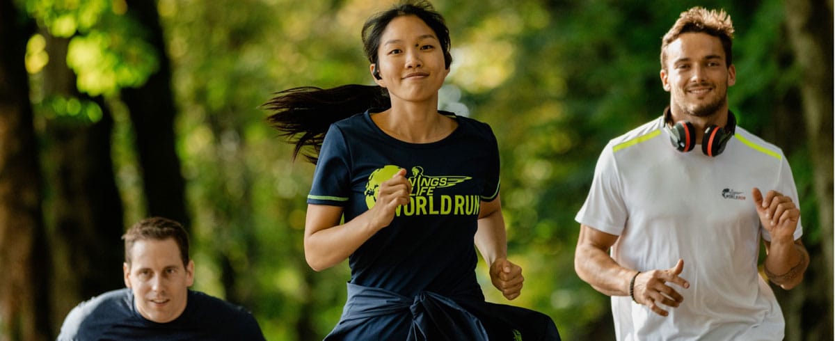 Kolm Wings for Life World Run osalejat jooksevad rõõmsalt, kandes Philipsi spordikõrvaklappe.
