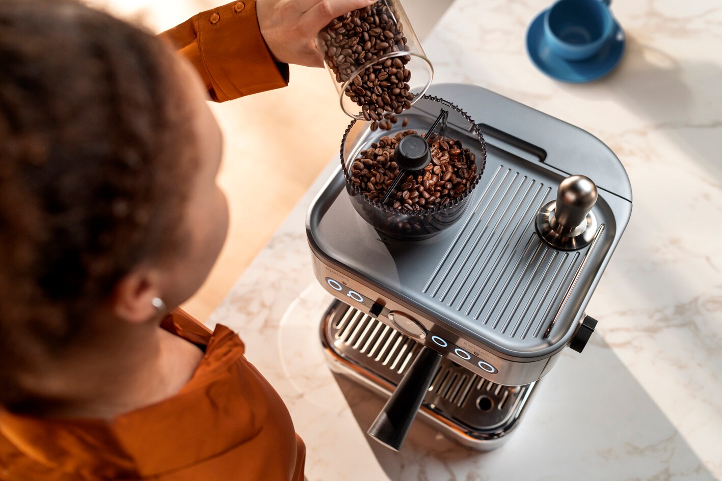 Noor naine valab kohviube Philips Barista Brew kohviubade mahutisse